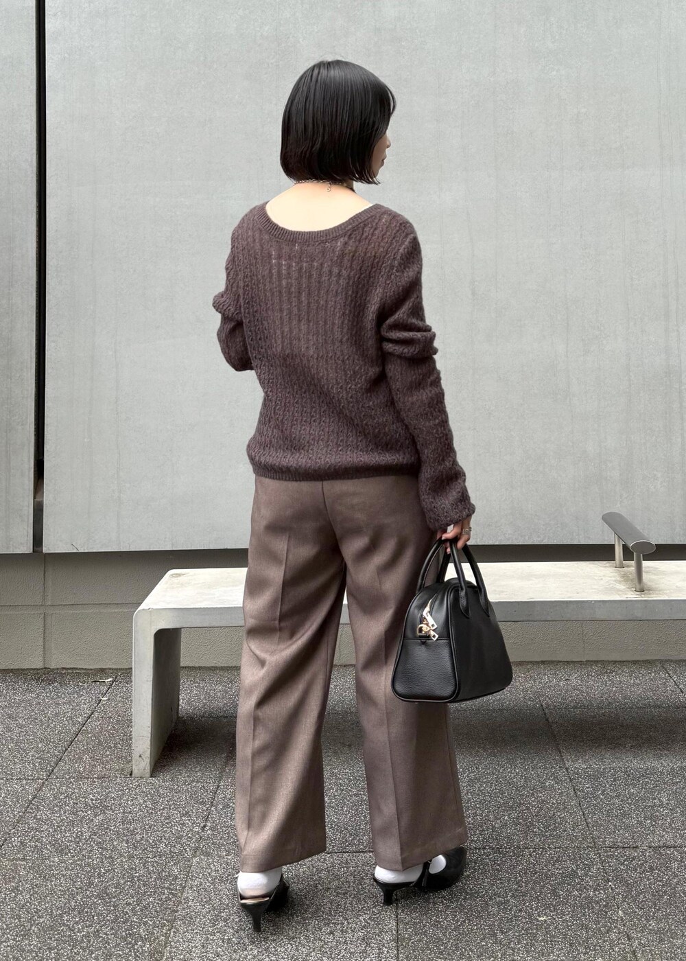 ブラウン系のカーディガン/ボレロ、ベージュ系のスラックス、ブラック系のボストンバッグを着用したレディースの秋コーディネートの6枚目の写真