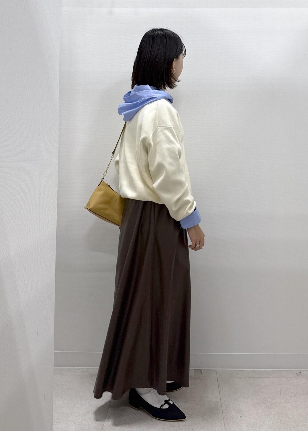 ブラウン系のショルダーバッグ、ブラウン系のスカート、ブラック系のパンプスを着用したレディースの秋コーディネートの8枚目の写真