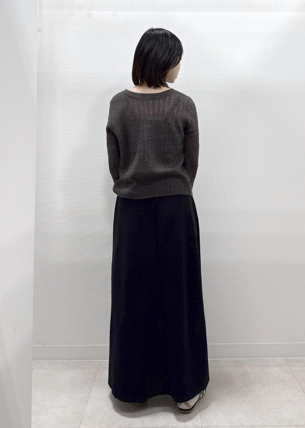 ブラック系のスカート、ブラウン系のカーディガン/ボレロ、レッド系のショルダーバッグを着用したレディースの秋コーディネートの5枚目の写真