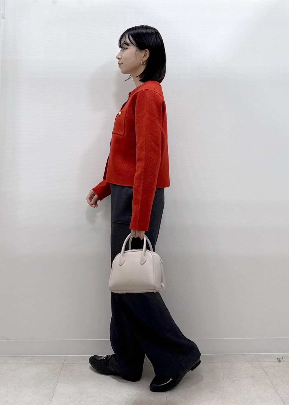レッド系のカーディガン/ボレロ、グレー系のその他パンツ、ブラック系のローファーを着用したレディースの秋コーディネートの5枚目の写真