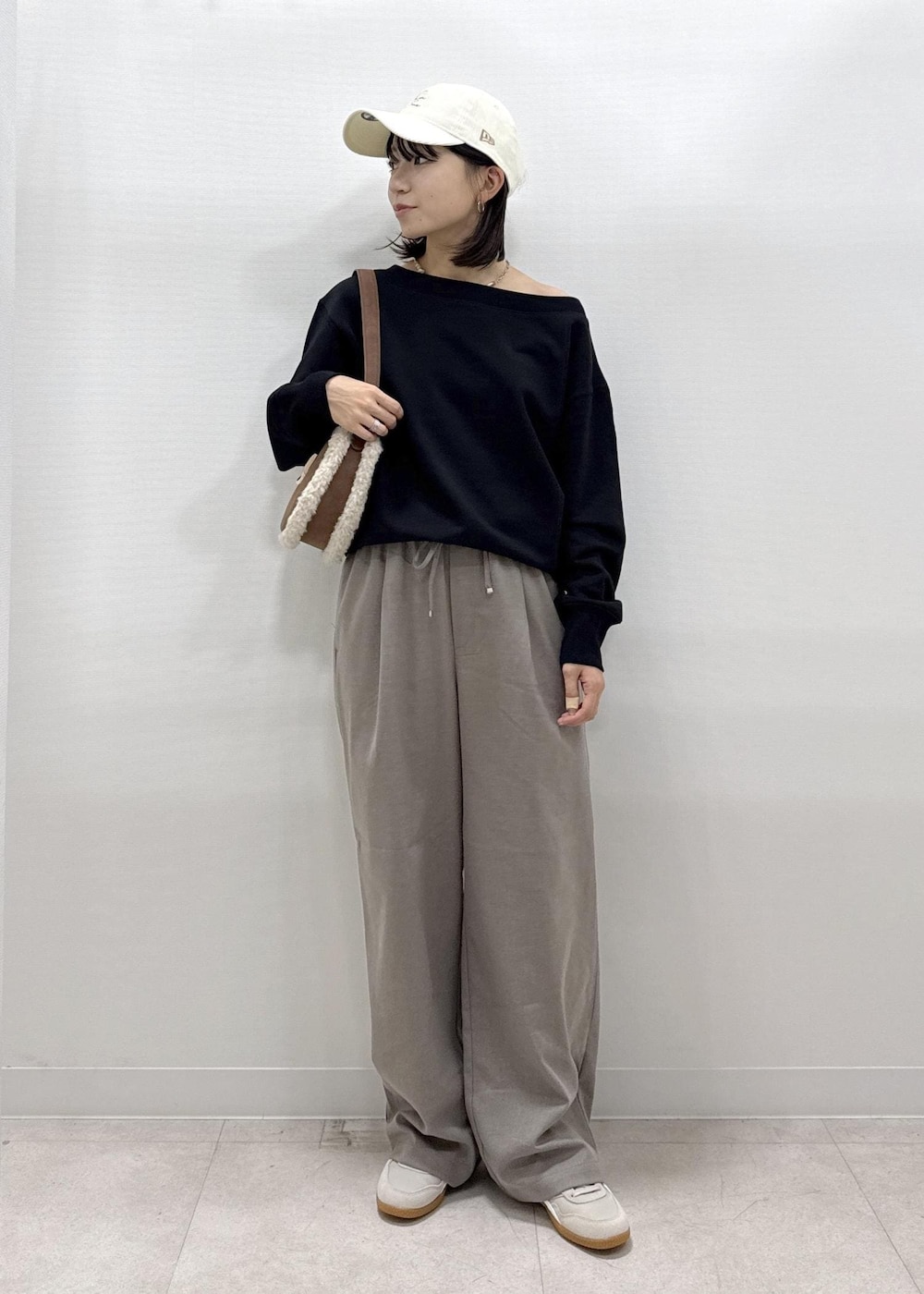 ベージュ系のその他パンツ、ブラック系のスウェット、ブラウン系のショルダーバッグを着用したレディースの秋コーディネートの2枚目の写真
