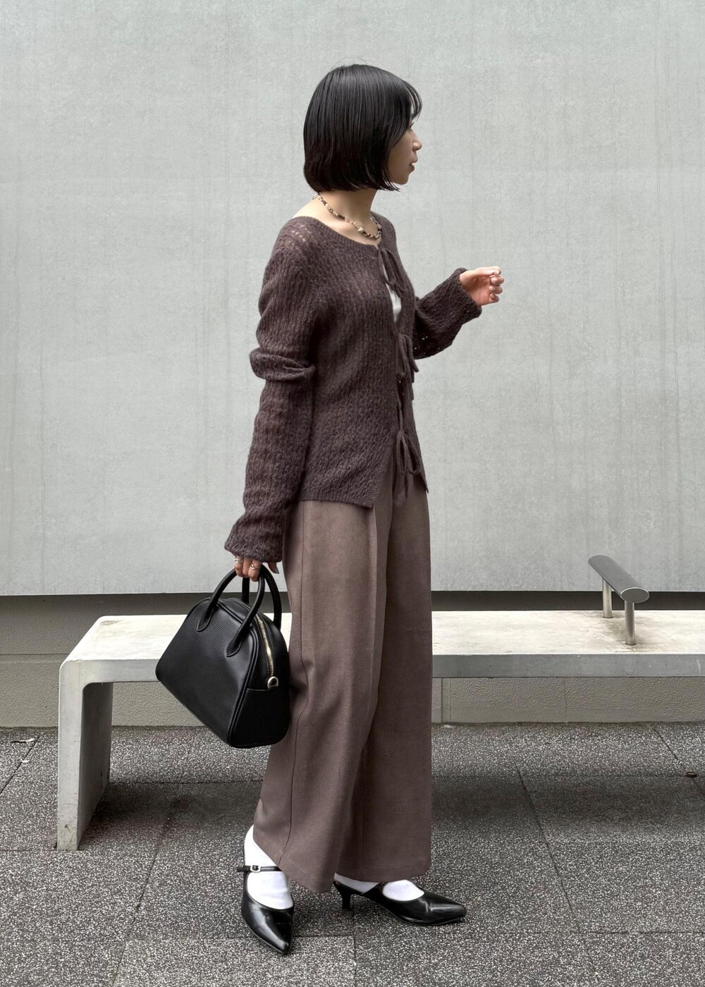 ブラウン系のカーディガン/ボレロ、ベージュ系のスラックス、ブラック系のボストンバッグを着用したレディースの秋コーディネートの8枚目の写真