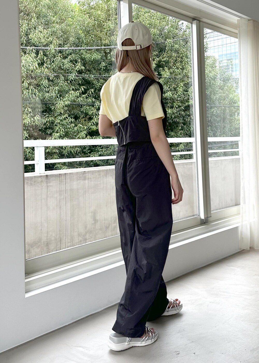 シルバー系のサンダル、グレー系のベスト、イエロー系のTシャツ/カットソーを着用したレディースの春コーディネートの6枚目の写真