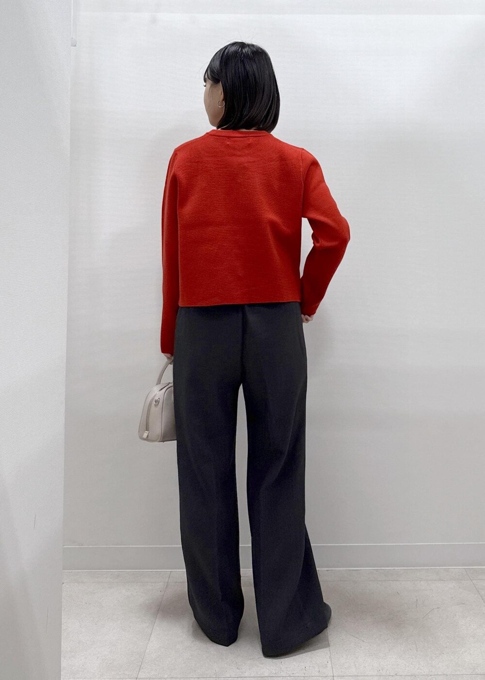 レッド系のカーディガン/ボレロ、グレー系のその他パンツ、ブラック系のローファーを着用したレディースの秋コーディネートの4枚目の写真