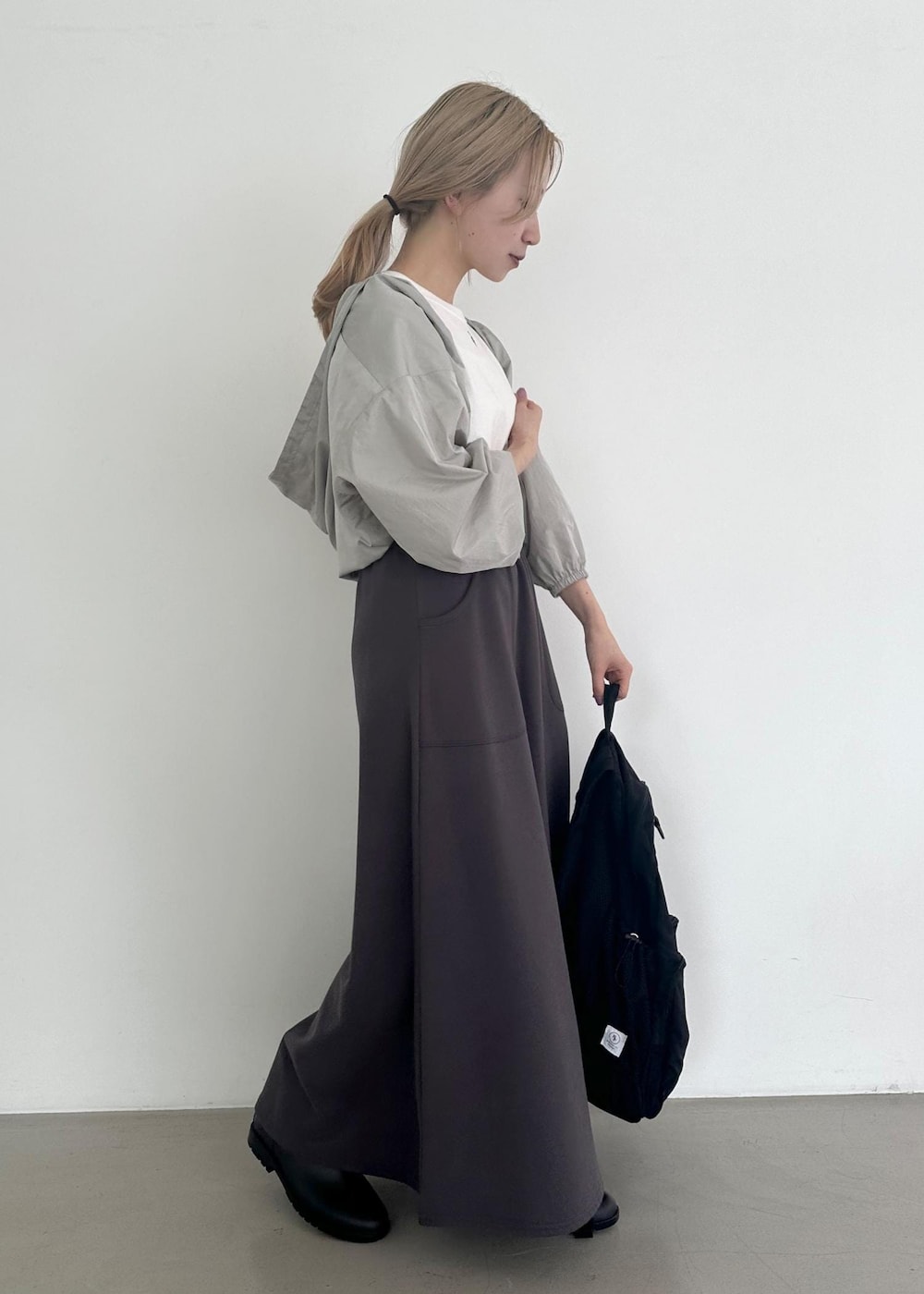 ブラック系のバックパック/リュック、グレー系のスカート、グレー系のその他アウターを着用したレディースの夏コーディネートの5枚目の写真