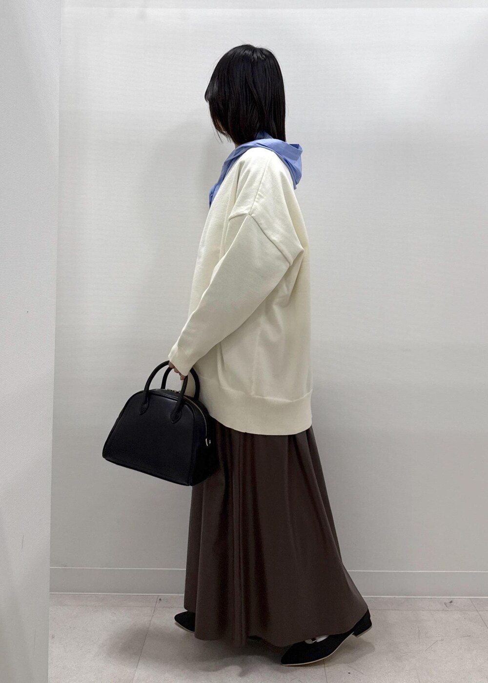 ブラウン系のスカート、ブラック系のパンプス、ブルー系のシャツ/ブラウスを着用したレディースの秋コーディネートの4枚目の写真