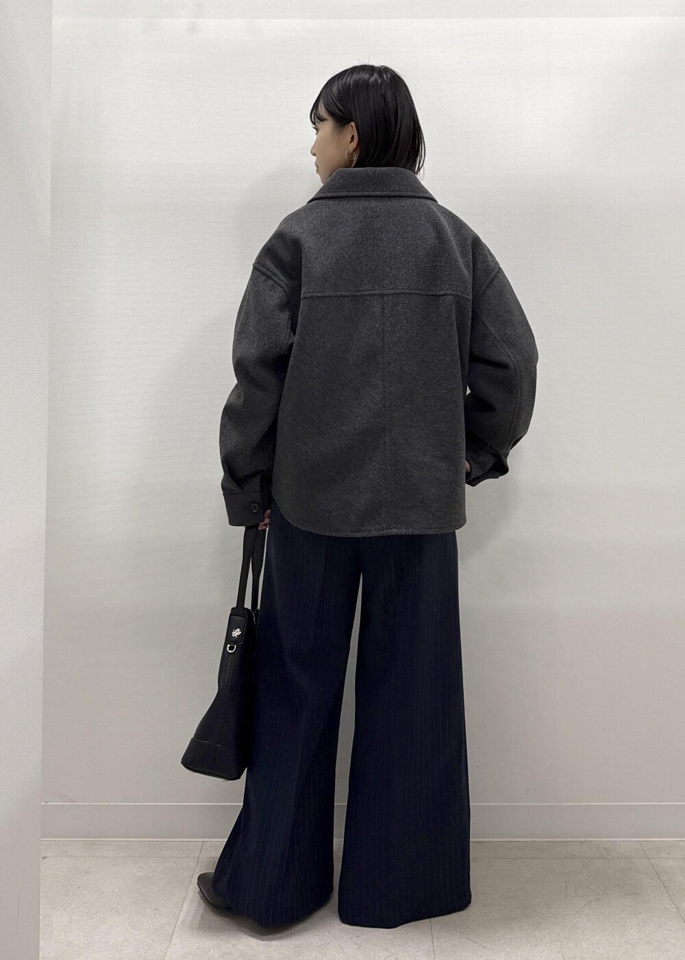 ブラック系のショルダーバッグ、ブルー系のその他パンツ、レッド系のニット/セーターを着用したレディースの秋コーディネートの3枚目の写真