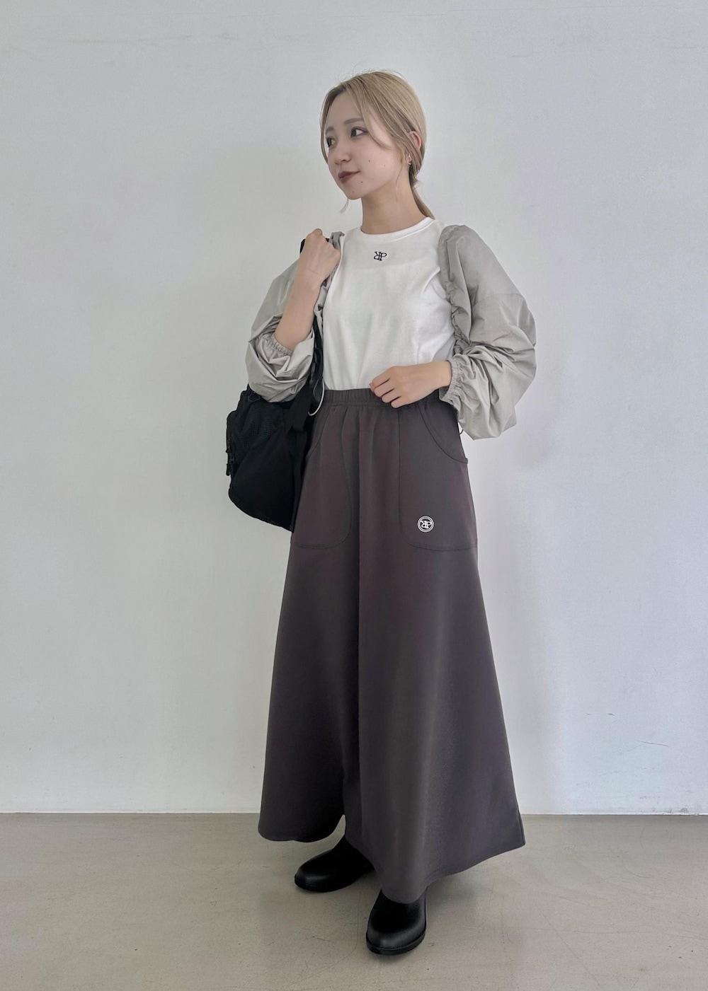 ブラック系のバックパック/リュック、グレー系のスカート、グレー系のその他アウターを着用したレディースの夏コーディネートの3枚目の写真