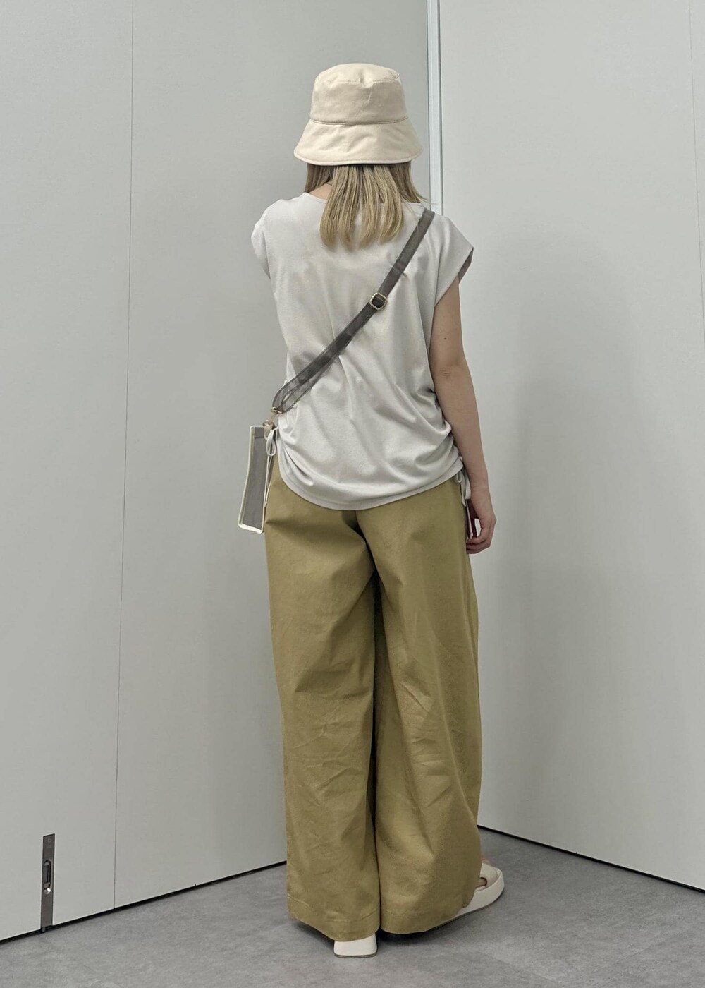 ホワイト系のサンダル、イエロー系のその他パンツ、ベージュ系のTシャツ/カットソーを着用したレディースの春コーディネートの5枚目の写真