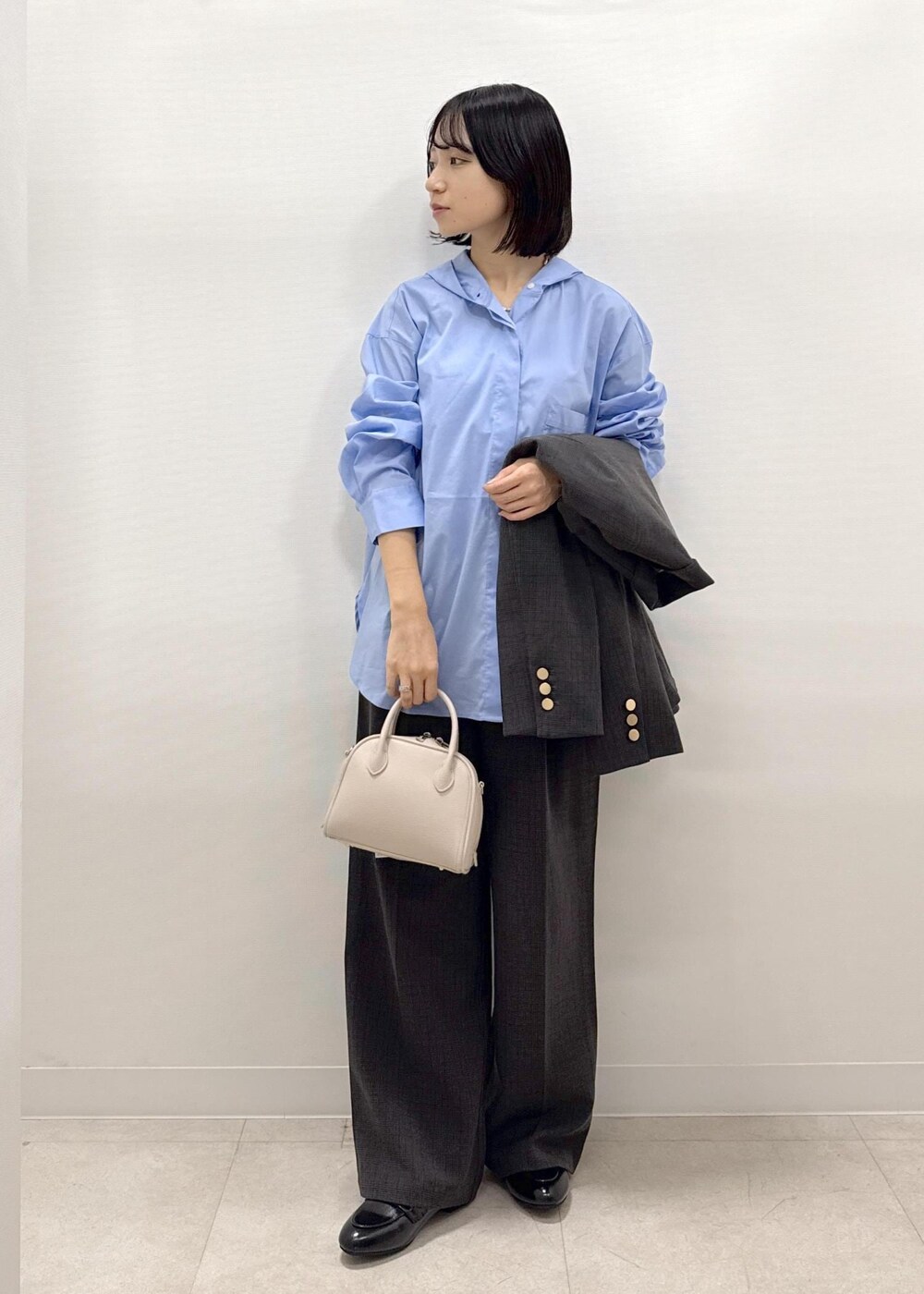 ブラック系のテーラードジャケット、ブラック系のスラックス、ブラック系のパンプスを着用したレディースの秋コーディネートの2枚目の写真