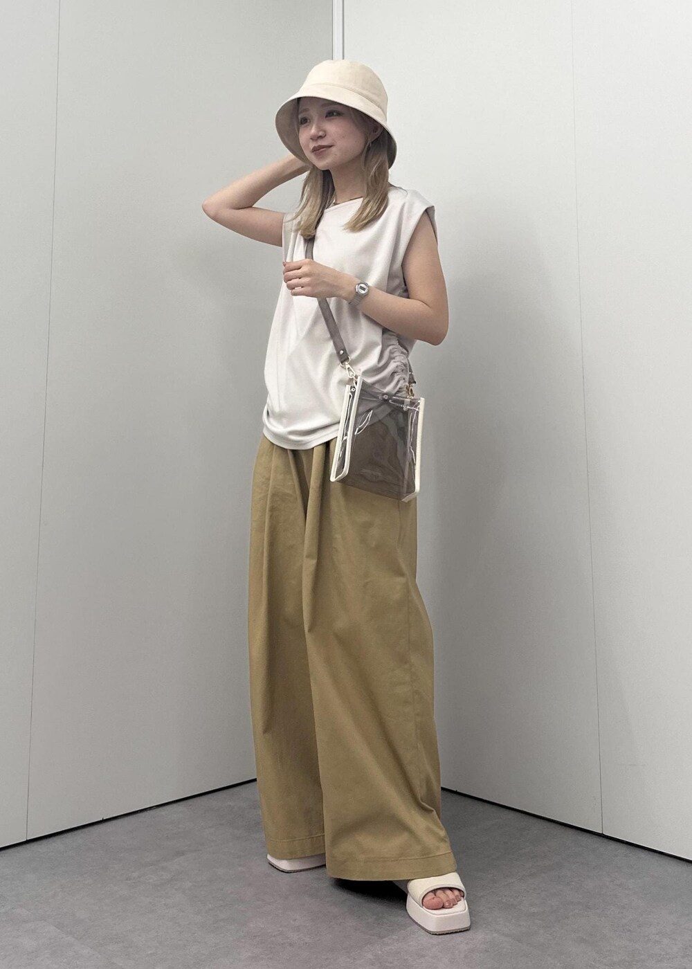 ホワイト系のサンダル、イエロー系のその他パンツ、ベージュ系のTシャツ/カットソーを着用したレディースの春コーディネートの2枚目の写真