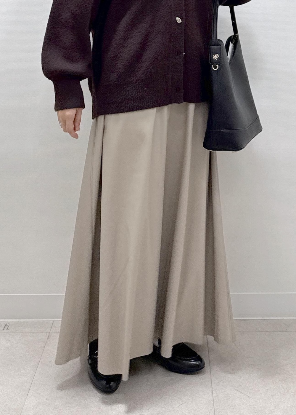 ベージュ系のスカート、ブラウン系のカーディガン/ボレロ、ブラック系のローファーを着用したレディースの秋コーディネートの9枚目の写真