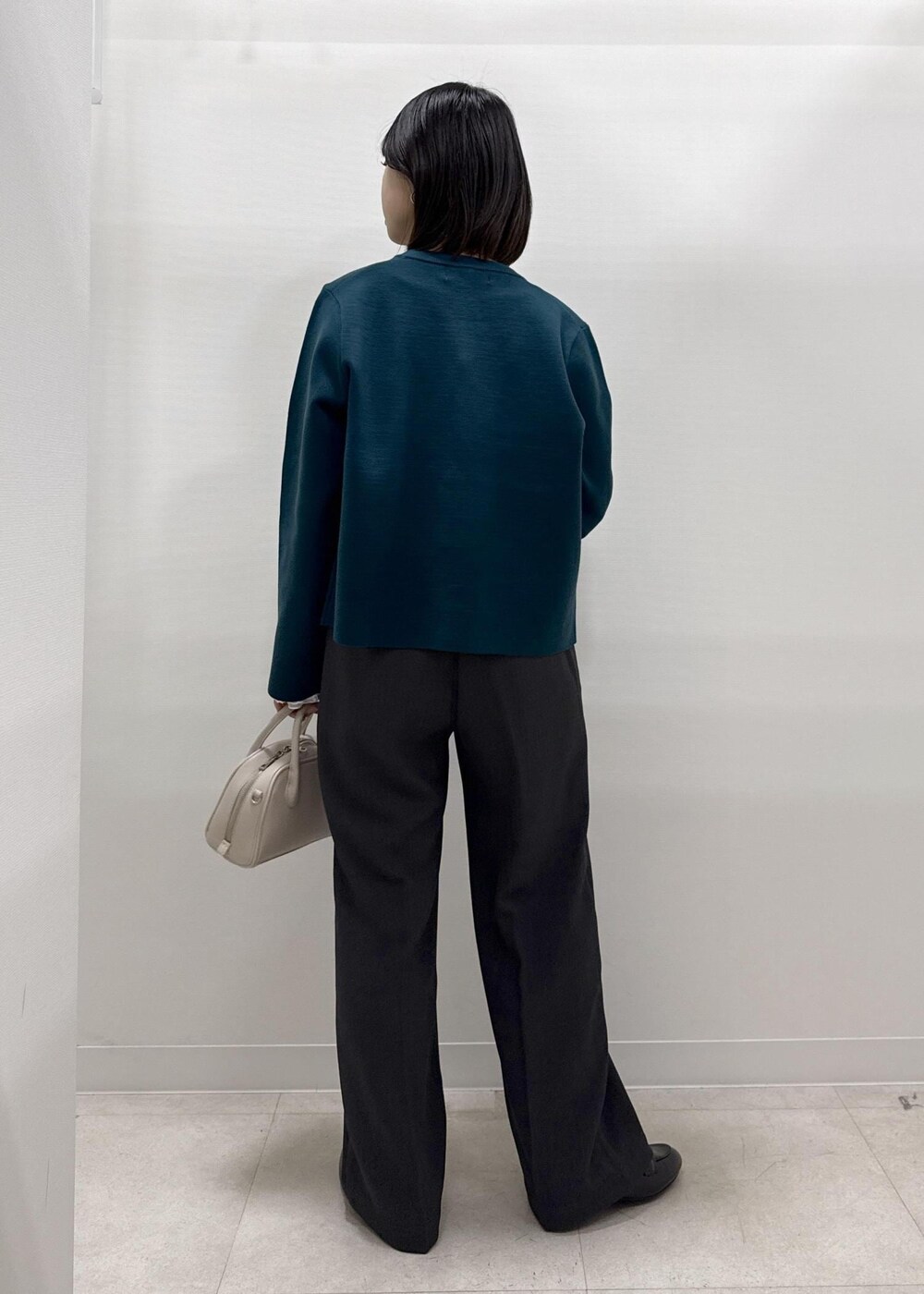 グレー系のその他パンツ、グリーン系のカーディガン/ボレロ、ブラック系のローファーを着用したレディースの秋コーディネートの5枚目の写真