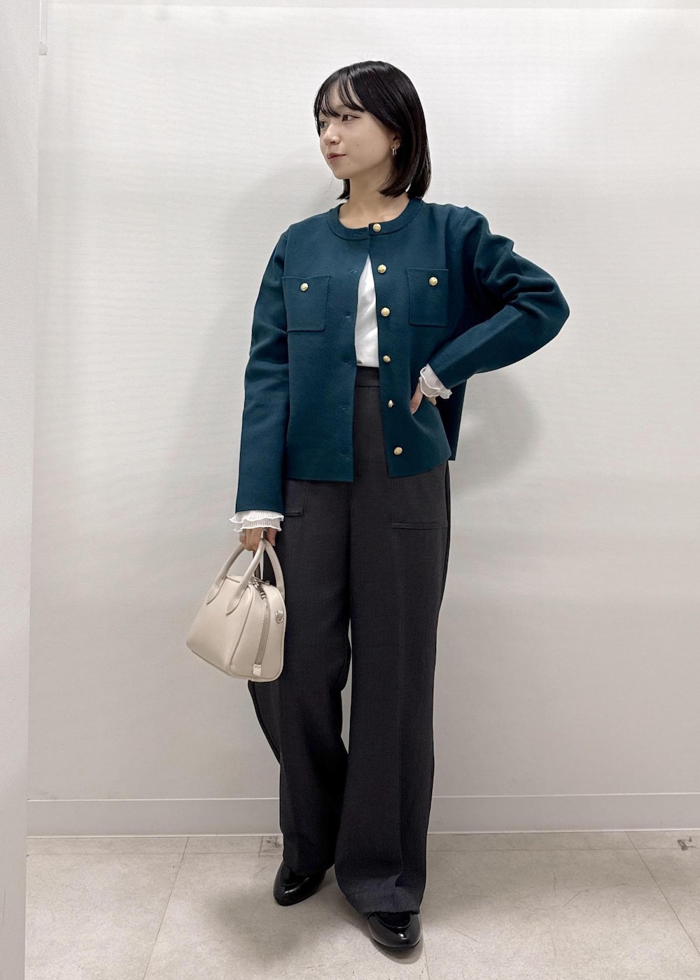 グレー系のその他パンツ、グリーン系のカーディガン/ボレロ、ブラック系のローファーを着用したレディースの秋コーディネートの8枚目の写真