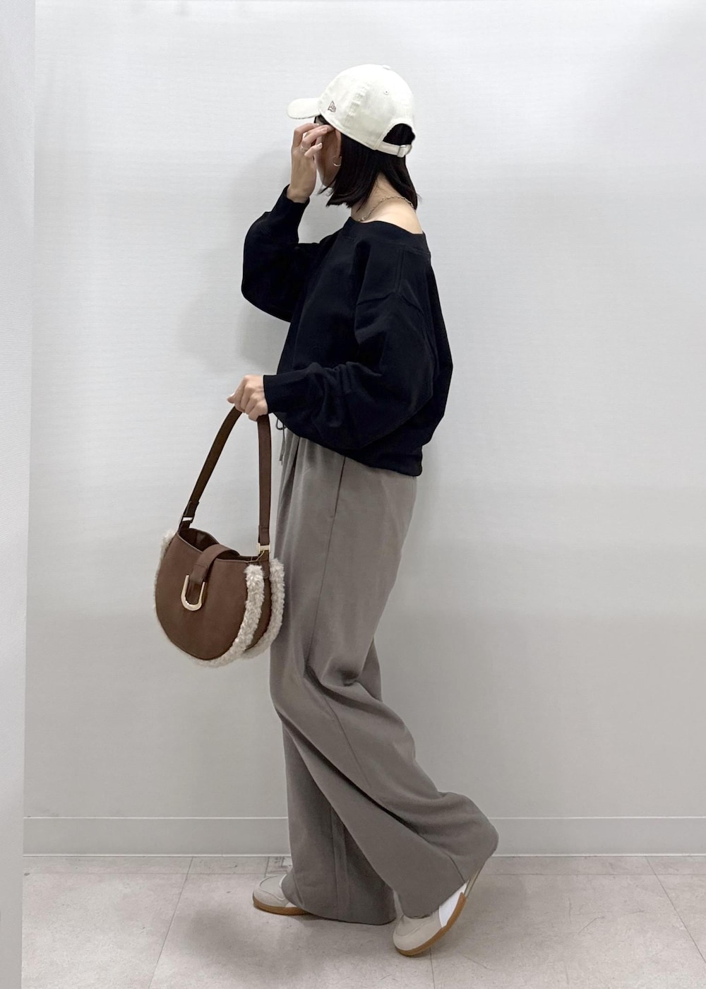 ベージュ系のその他パンツ、ブラック系のスウェット、ブラウン系のショルダーバッグを着用したレディースの秋コーディネートの4枚目の写真