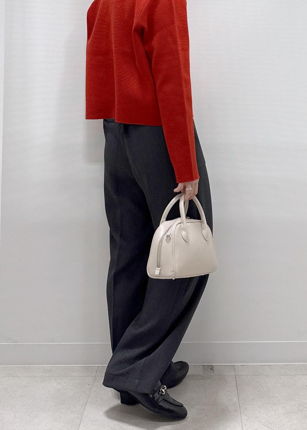 レッド系のカーディガン/ボレロ、グレー系のその他パンツ、ブラック系のローファーを着用したレディースの秋コーディネートの9枚目の写真