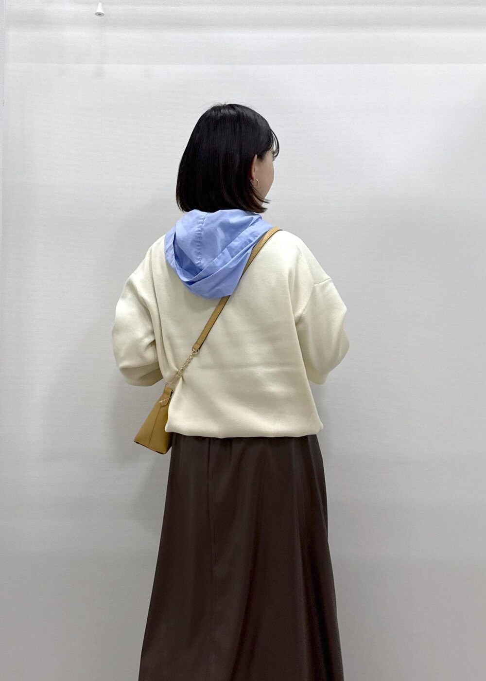 ブラウン系のショルダーバッグ、ブラウン系のスカート、ブラック系のパンプスを着用したレディースの秋コーディネートの6枚目の写真