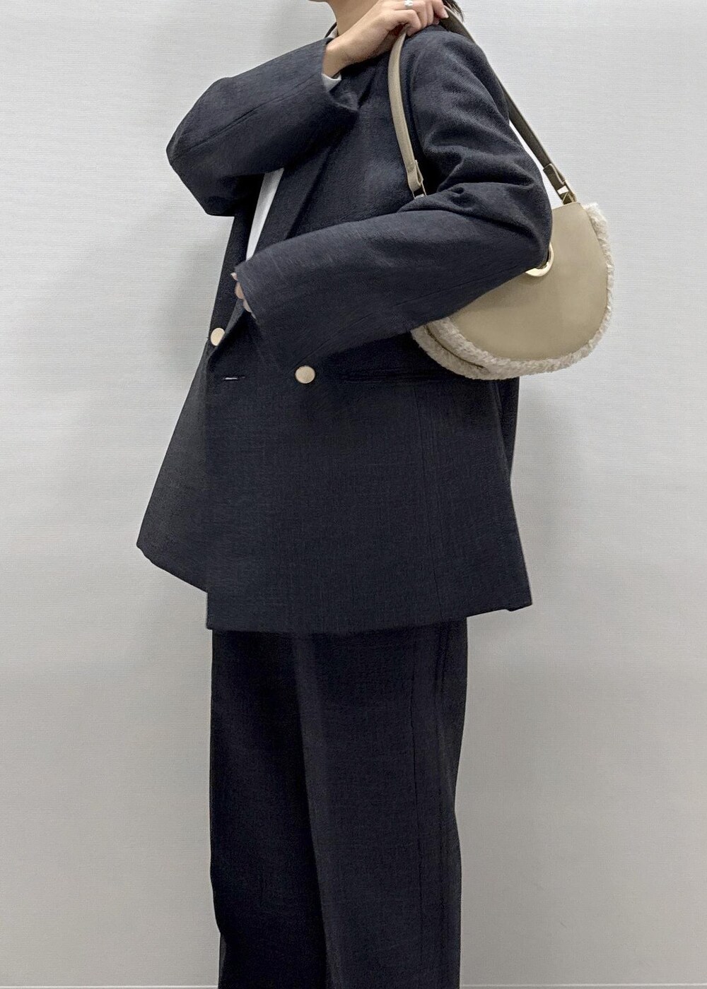 ホワイト系のパンプス、ホワイト系のシャツ/ブラウス、グレー系のテーラードジャケットを着用したレディースの秋コーディネートの2枚目の写真