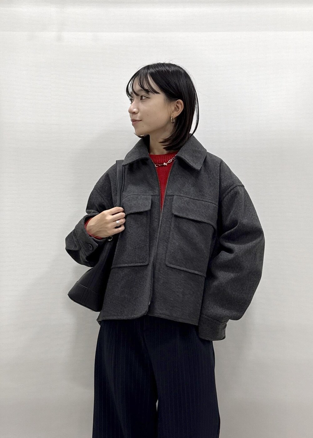 ブラック系のショルダーバッグ、ブルー系のその他パンツ、レッド系のニット/セーターを着用したレディースの秋コーディネートの7枚目の写真