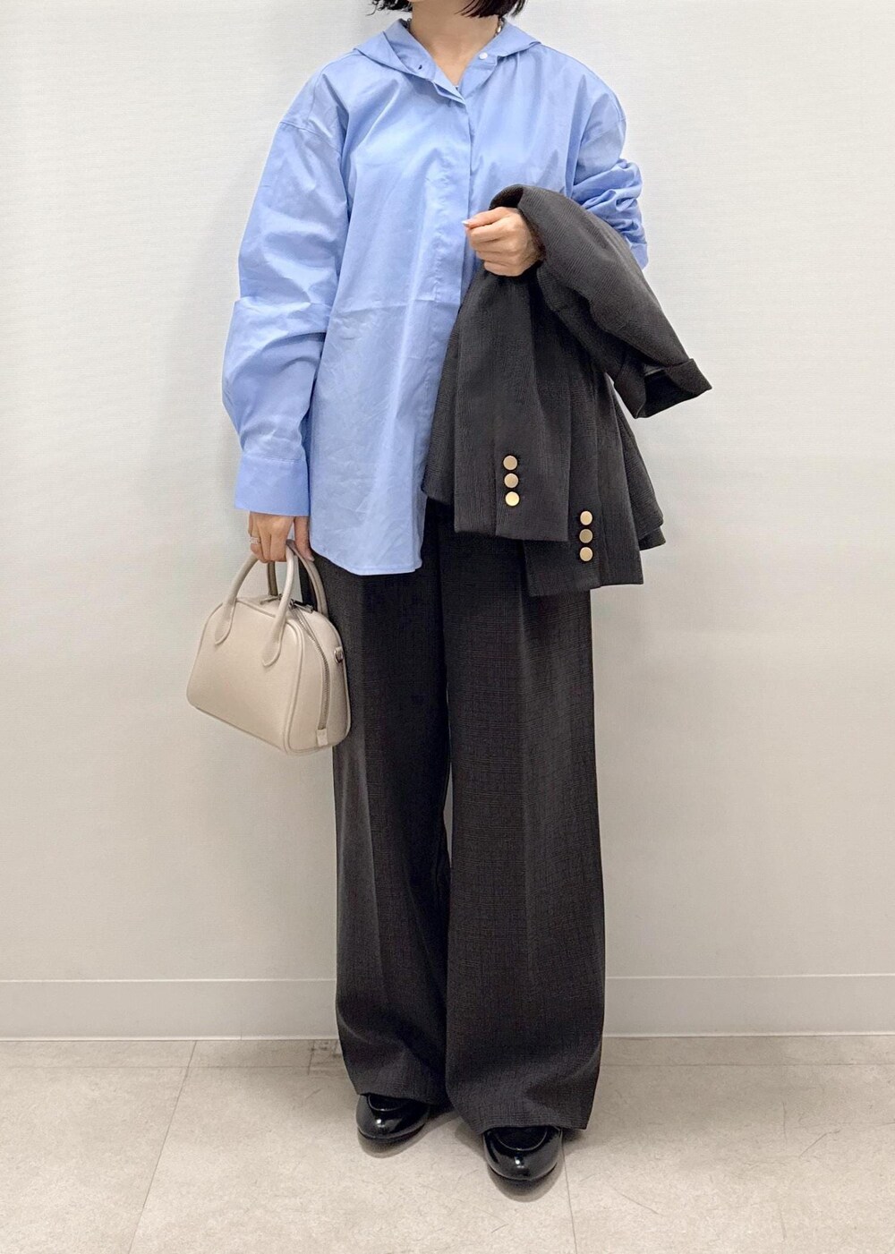 ブラック系のテーラードジャケット、ブラック系のスラックス、ブラック系のパンプスを着用したレディースの秋コーディネートの9枚目の写真