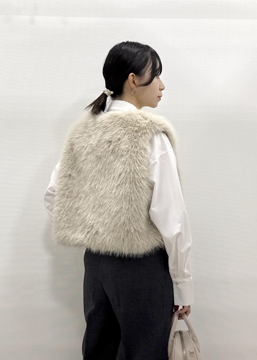 ベージュ系のベスト、ホワイト系のシャツ/ブラウス、グレー系のスラックスを着用したレディースの秋コーディネートの7枚目の写真