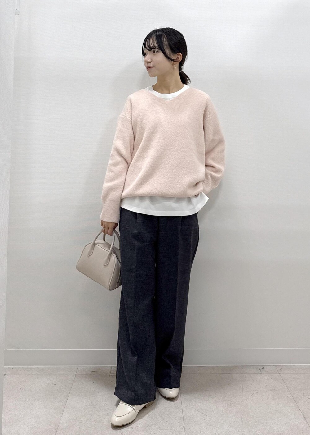 ホワイト系のパンプス、ピンク系のニット/セーター、ホワイト系のTシャツ/カットソーを着用したレディースの秋コーディネートの3枚目の写真