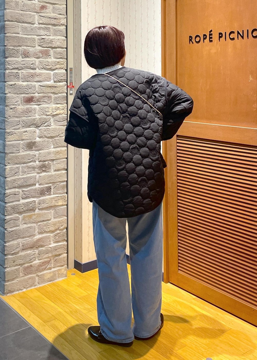 ホワイト系のニット/セーター、ブラック系のショルダーバッグ、グレー系のベストを着用したレディースの冬コーディネートの3枚目の写真