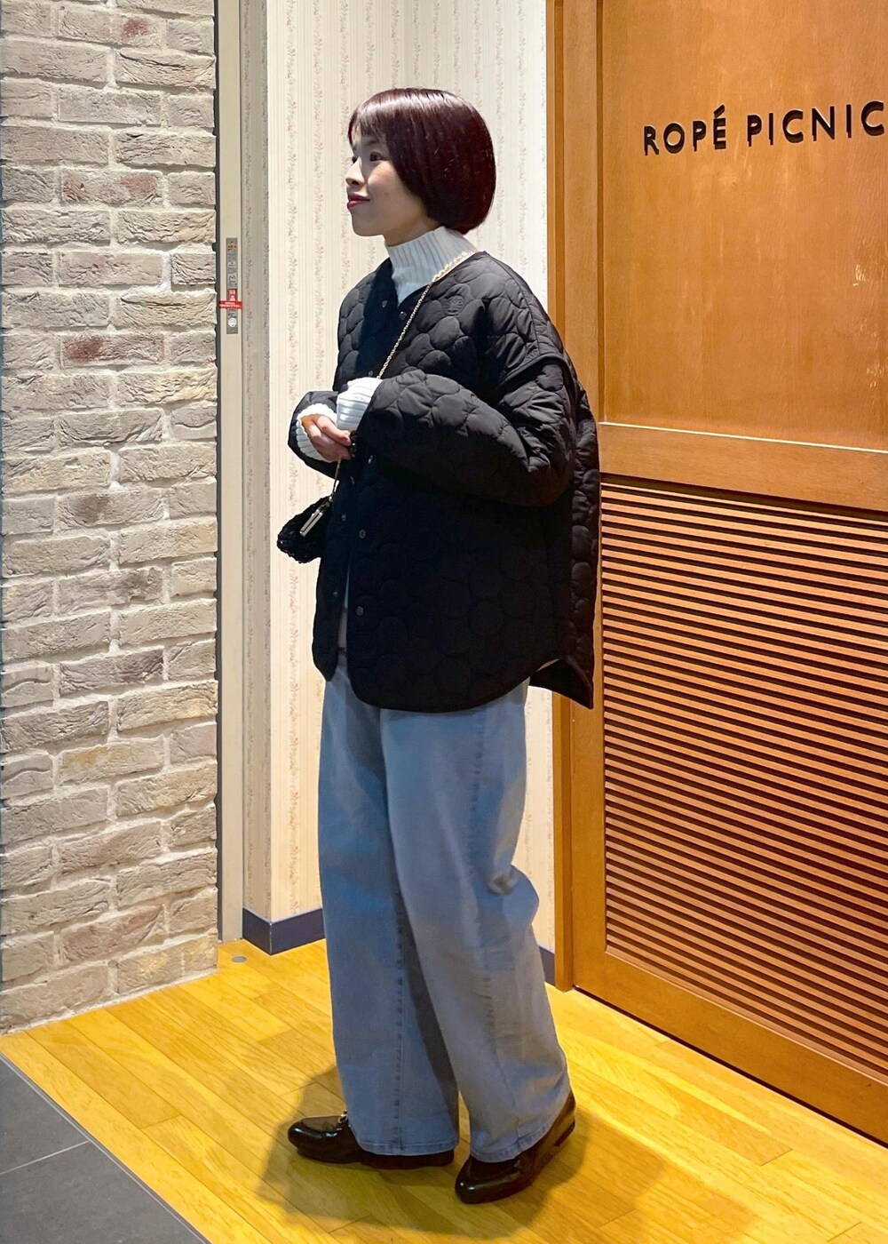 ホワイト系のニット/セーター、ブラック系のショルダーバッグ、グレー系のベストを着用したレディースの冬コーディネートの2枚目の写真