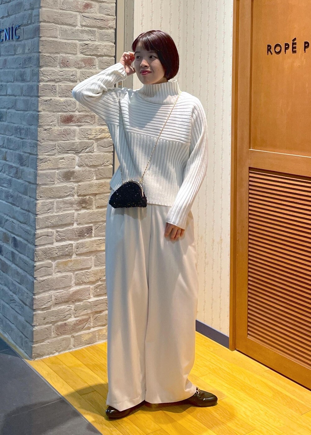 ホワイト系のニット/セーター、グリーン系のその他アウター、ブラック系のショルダーバッグを着用したレディースの冬コーディネートの10枚目の写真