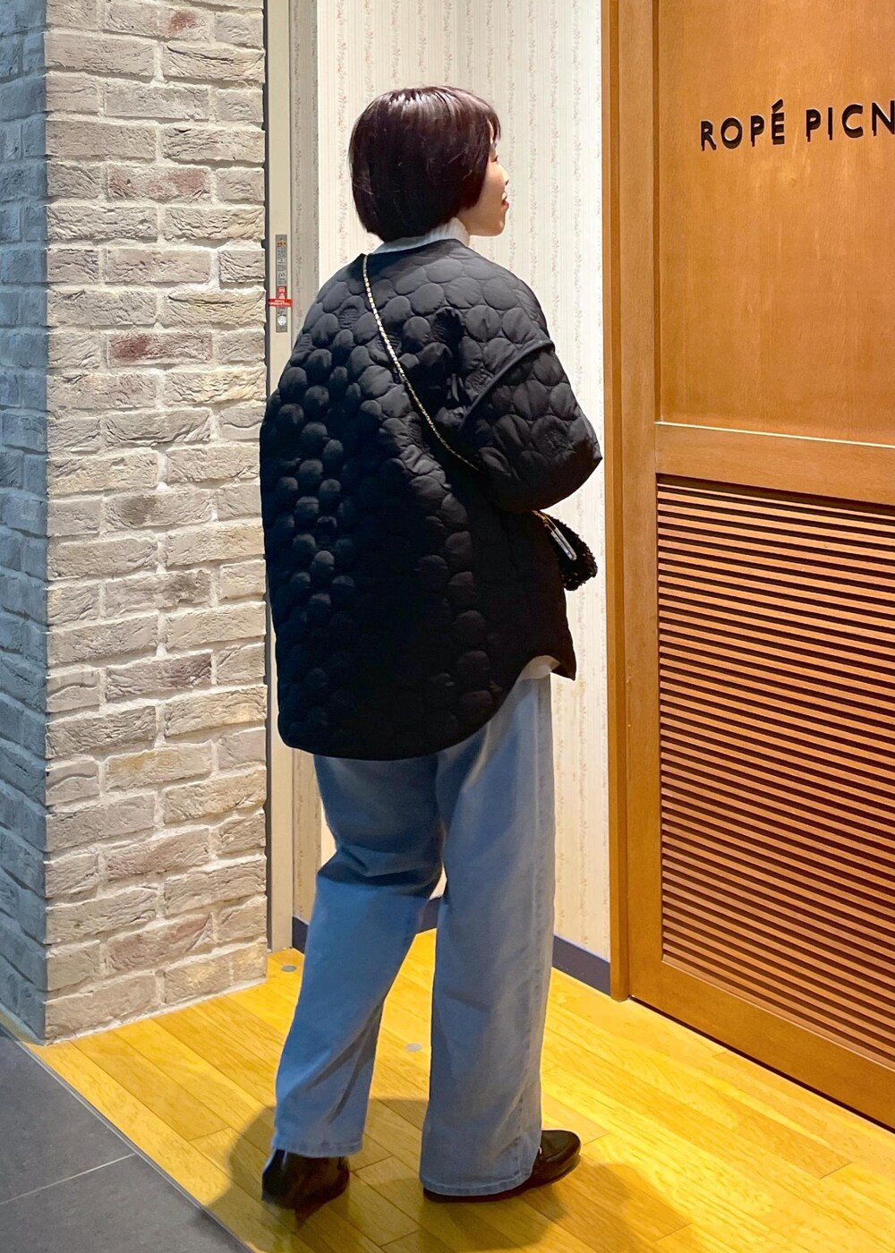 ホワイト系のニット/セーター、ブラック系のショルダーバッグ、グレー系のベストを着用したレディースの冬コーディネートの4枚目の写真