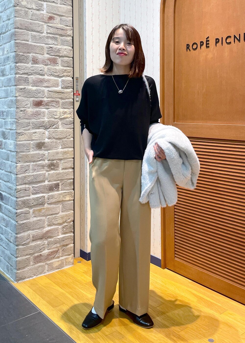 ホワイト系のその他アウター、ブラック系のニット/セーター、イエロー系のその他パンツを着用したレディースの秋コーディネートの9枚目の写真