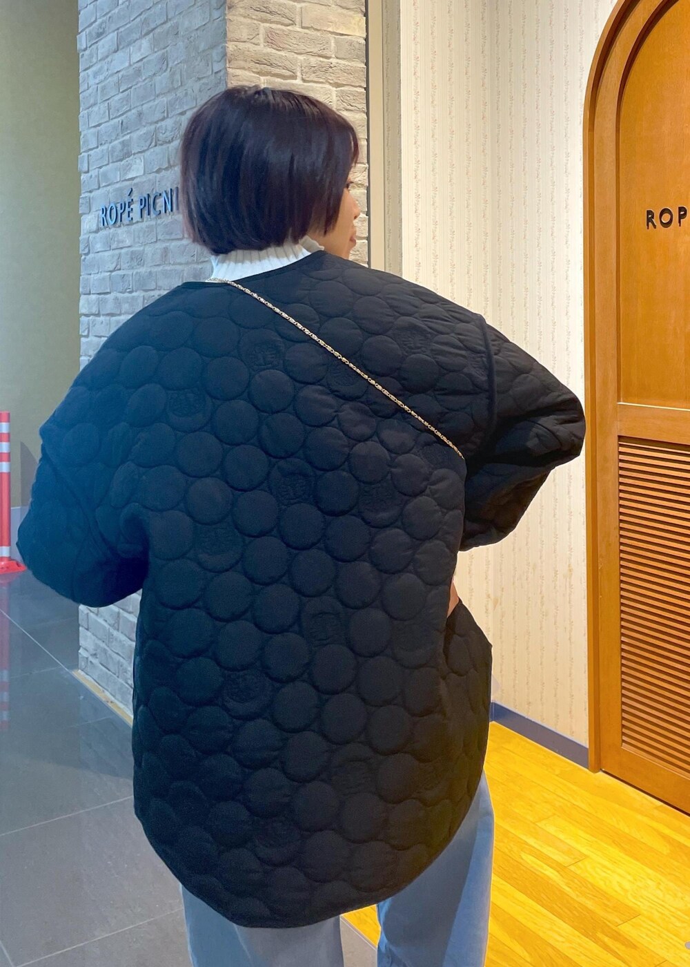 ホワイト系のニット/セーター、ブラック系のショルダーバッグ、グレー系のベストを着用したレディースの冬コーディネートの8枚目の写真