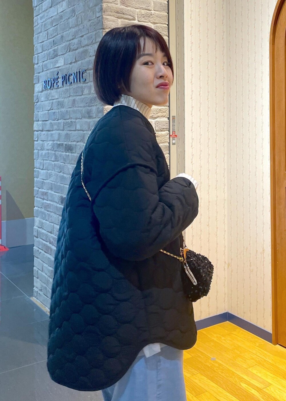 ホワイト系のニット/セーター、ブラック系のショルダーバッグ、グレー系のベストを着用したレディースの冬コーディネートの9枚目の写真