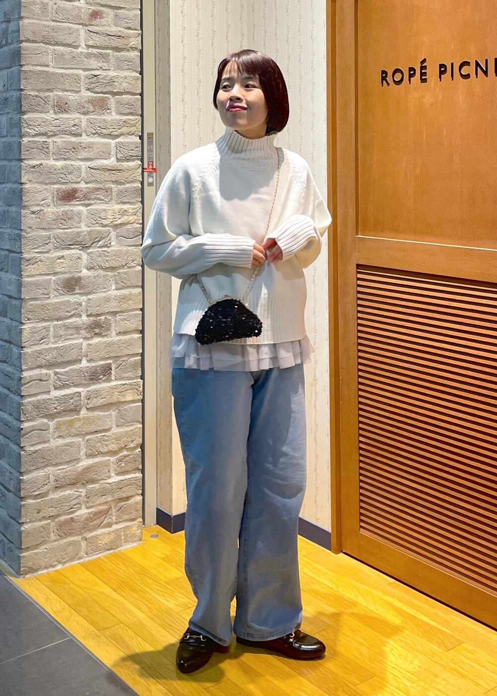 ホワイト系のニット/セーター、ブラック系のショルダーバッグ、グレー系のベストを着用したレディースの冬コーディネートの10枚目の写真