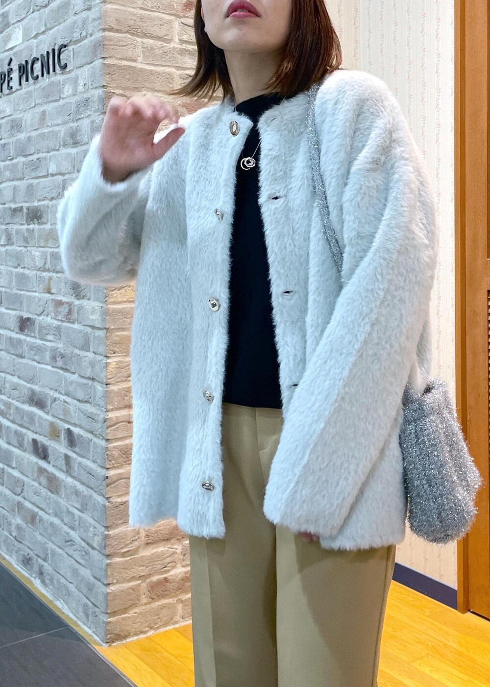 ホワイト系のその他アウター、ブラック系のニット/セーター、イエロー系のその他パンツを着用したレディースの秋コーディネートの4枚目の写真