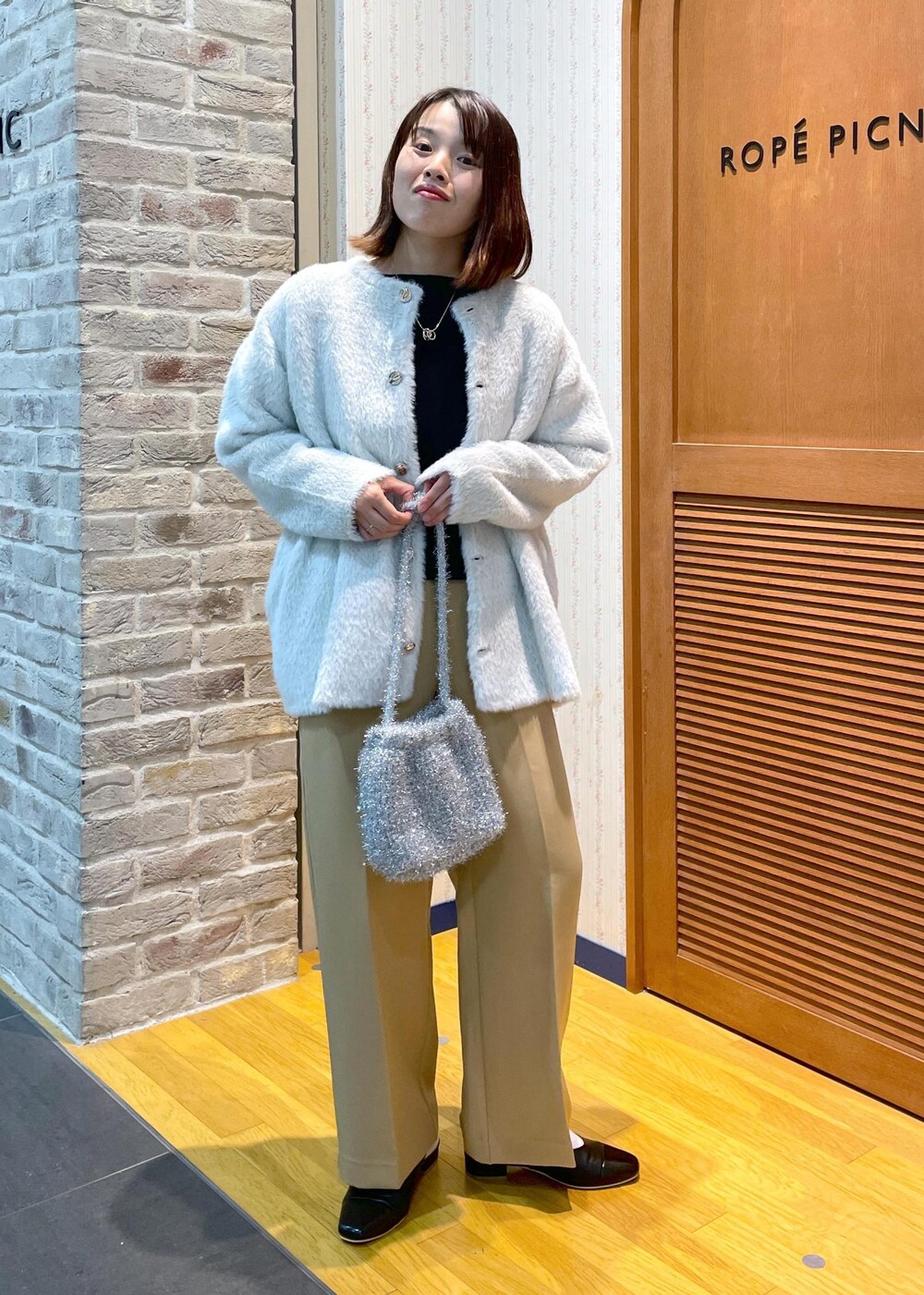 ホワイト系のその他アウター、ブラック系のニット/セーター、イエロー系のその他パンツを着用したレディースの秋コーディネートの8枚目の写真