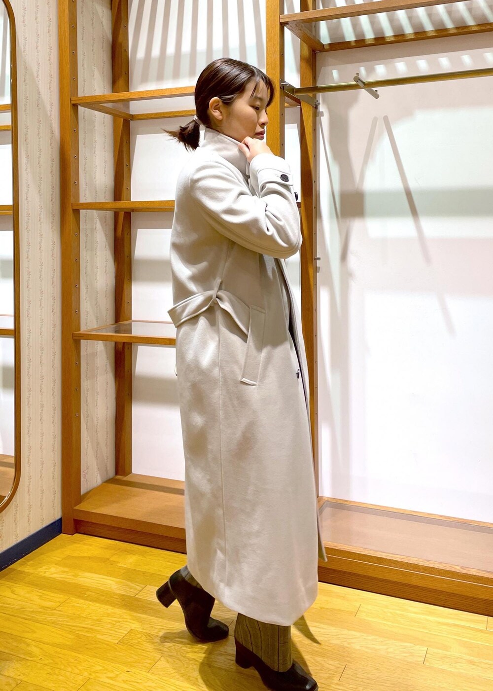 ブラック系のブーツ、ホワイト系のショルダーバッグ、レッド系のニット/セーターを着用したレディースの冬コーディネートの4枚目の写真