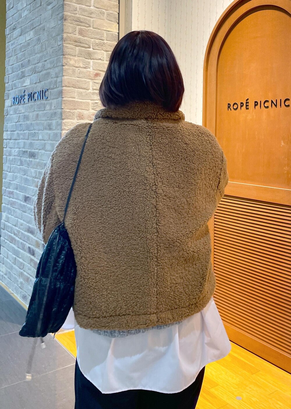 イエロー系のムートンコート、ブラック系のその他パンツ、グレー系のパンプスを着用したレディースの冬コーディネートの7枚目の写真