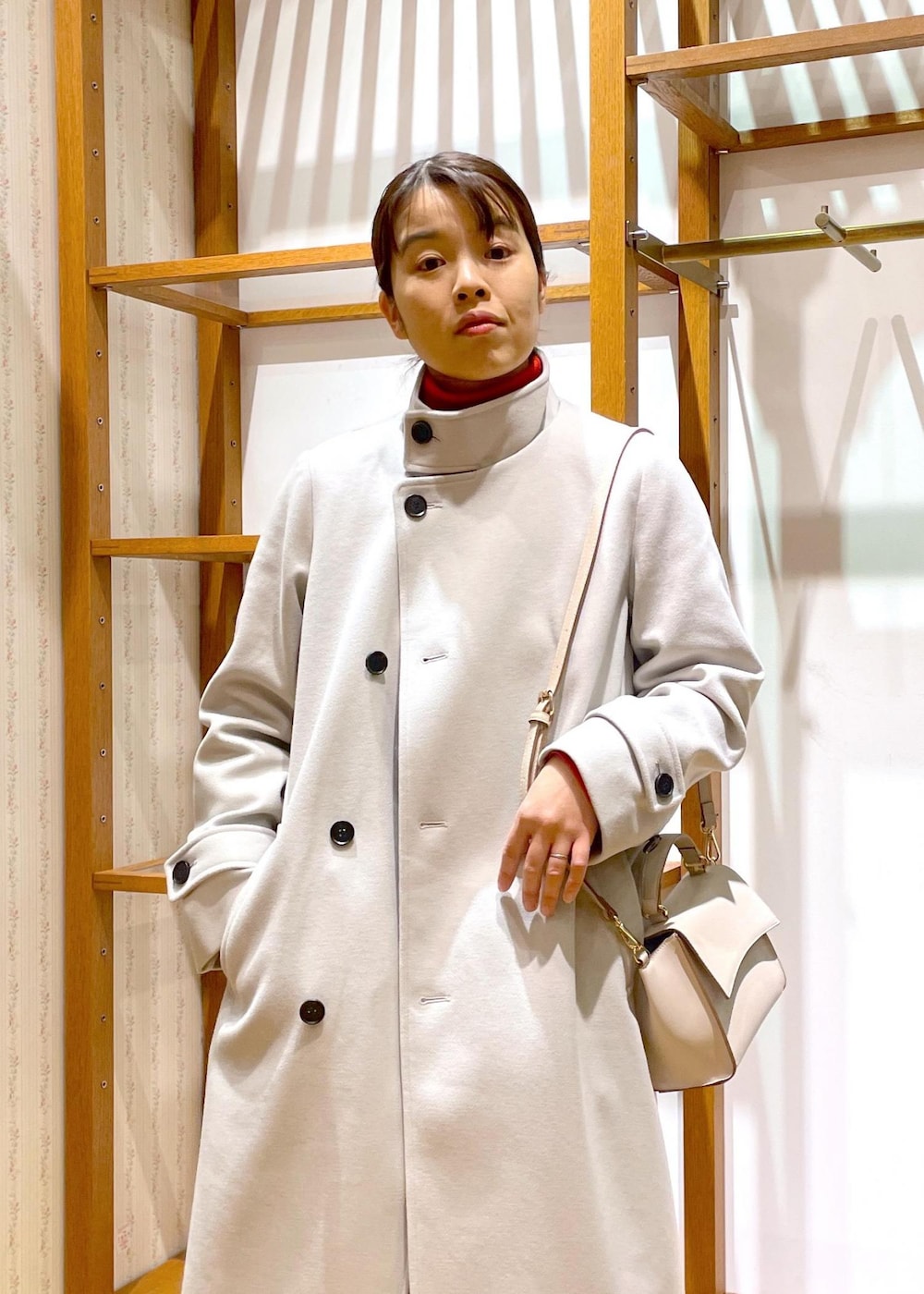 ブラック系のブーツ、ホワイト系のショルダーバッグ、レッド系のニット/セーターを着用したレディースの冬コーディネートの6枚目の写真