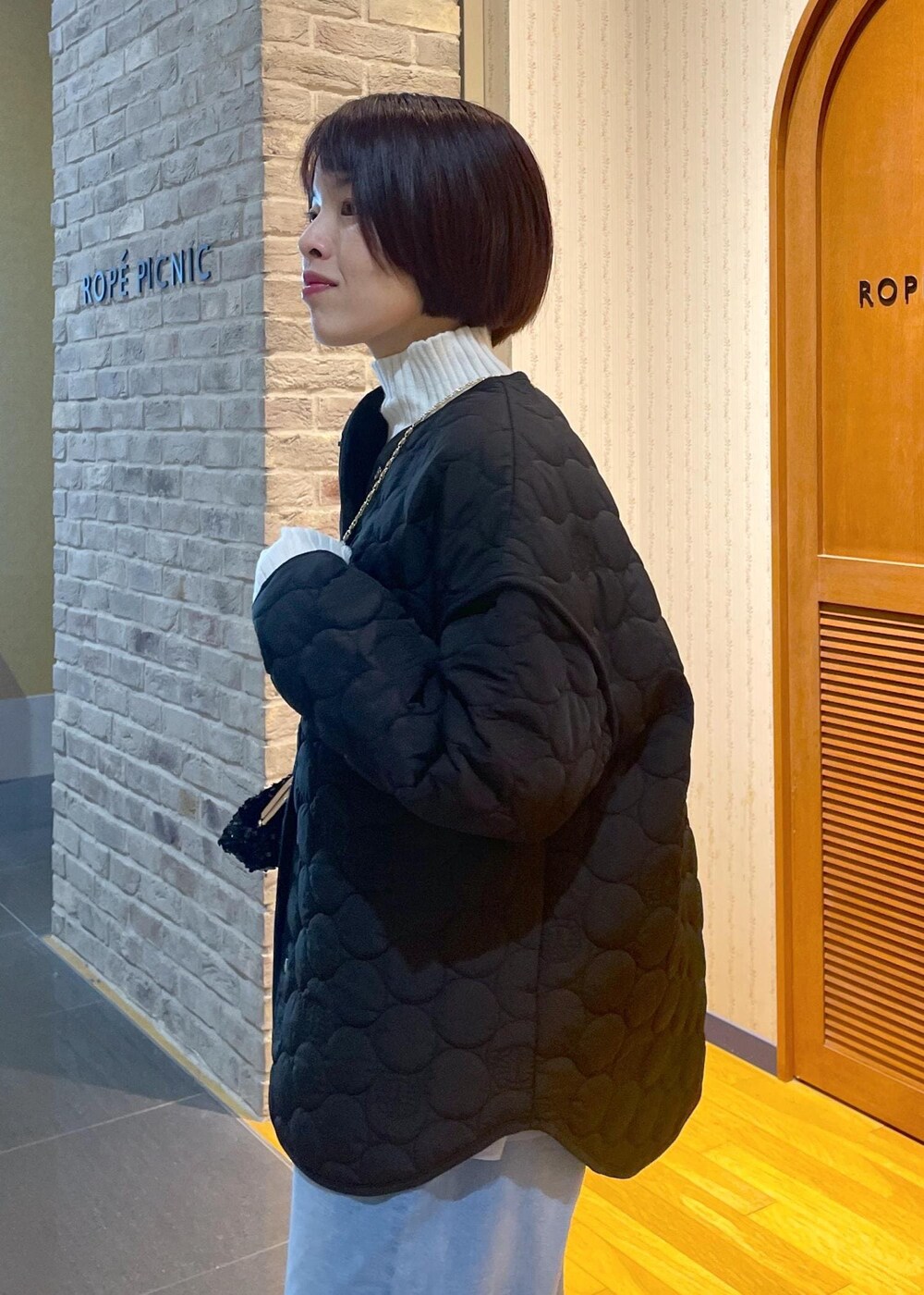 ホワイト系のニット/セーター、ブラック系のショルダーバッグ、グレー系のベストを着用したレディースの冬コーディネートの7枚目の写真