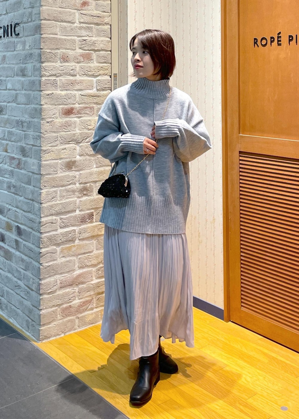 「ニットコーデ、ハイネックニット、オーバーサイズニット、グレーニット、グレーニットコーデ、ロングスカート、プリーツスカート、着丈が選べるスカート、ミニバッグ、スパンコールバッグ、スパンコール、チェーンショルダー、ロングブーツ、きれいめカジュアル、きれいめカジュアルコーデ」｜「ROPE' PICNICのセンターラインミドル丈ハイネックニットプルオーバー/帯電防止・洗濯機OK・リンクコーデ（ニット/セーター、グレー系）」を使った、Yuriさん（レディース・159cm）の冬コーディネートの5枚目の写真