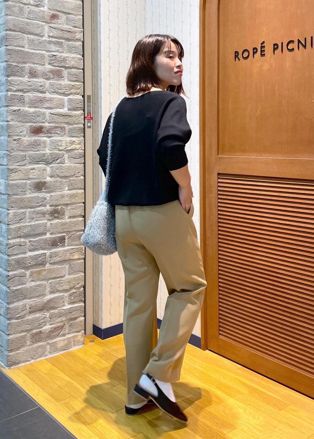 ホワイト系のその他アウター、ブラック系のニット/セーター、イエロー系のその他パンツを着用したレディースの秋コーディネートの10枚目の写真