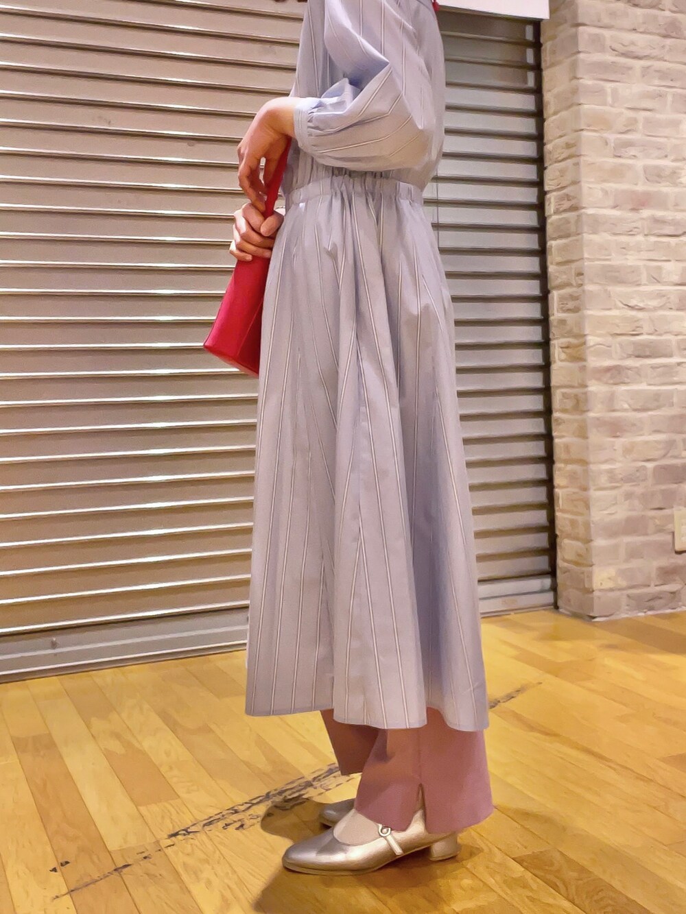 ピンク系のショルダーバッグ、ブルー系のワンピース、シルバー系のパンプスを着用したレディースの春コーディネートの2枚目の写真