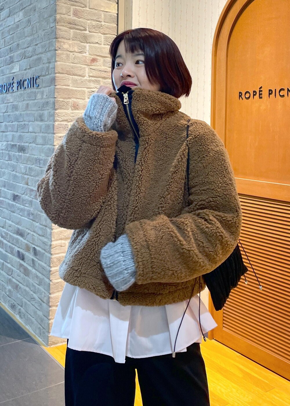 イエロー系のムートンコート、ブラック系のその他パンツ、グレー系のパンプスを着用したレディースの冬コーディネートの8枚目の写真