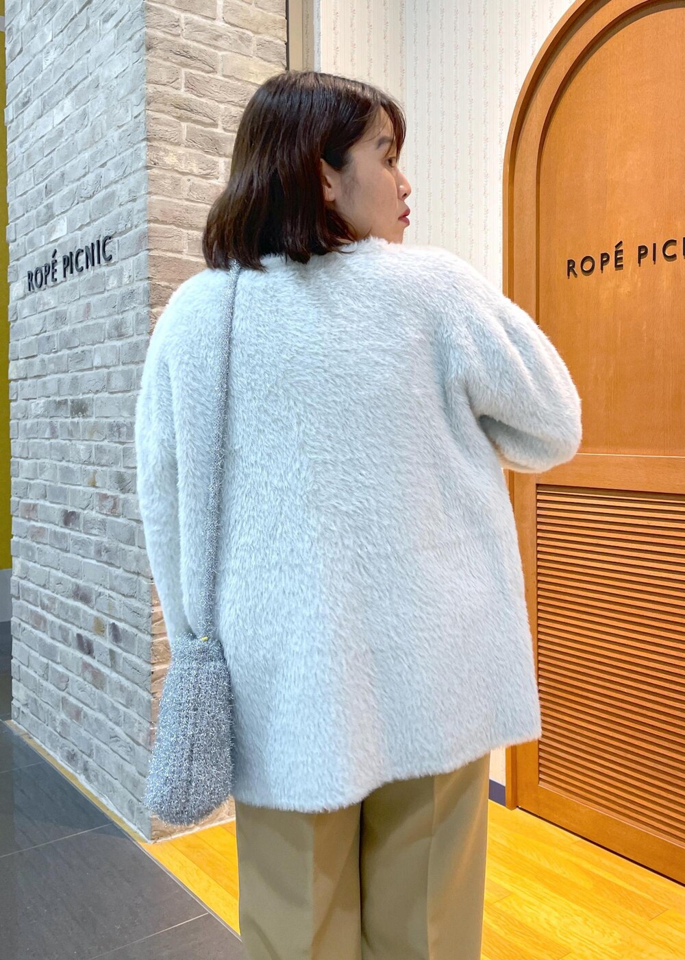 ホワイト系のその他アウター、ブラック系のニット/セーター、イエロー系のその他パンツを着用したレディースの秋コーディネートの6枚目の写真