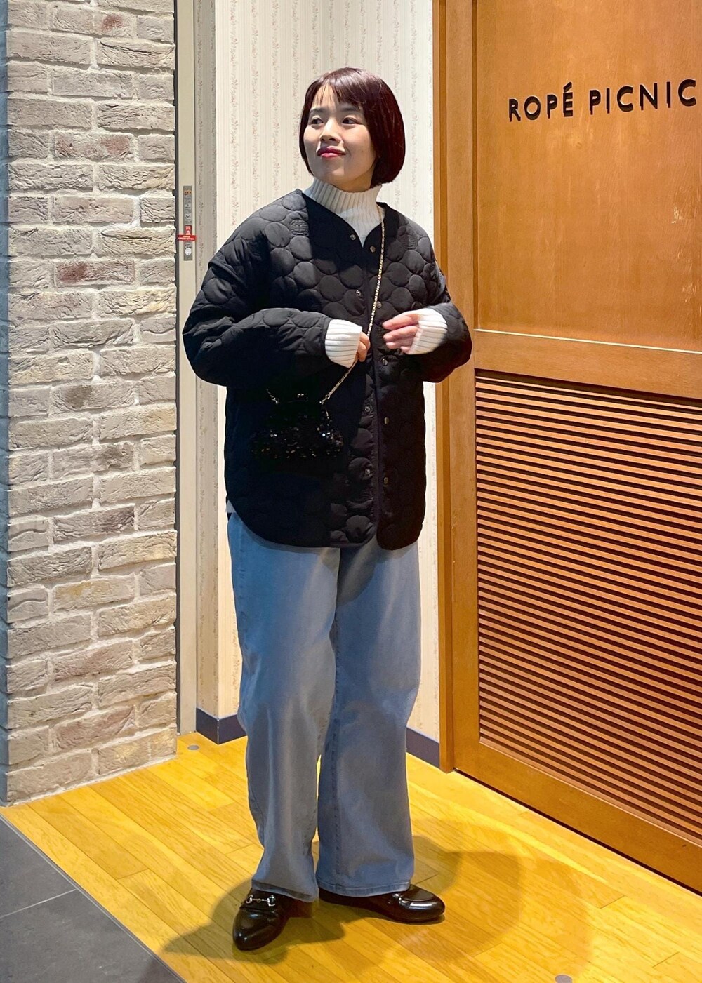 ホワイト系のニット/セーター、ブラック系のショルダーバッグ、グレー系のベストを着用したレディースの冬コーディネートの5枚目の写真