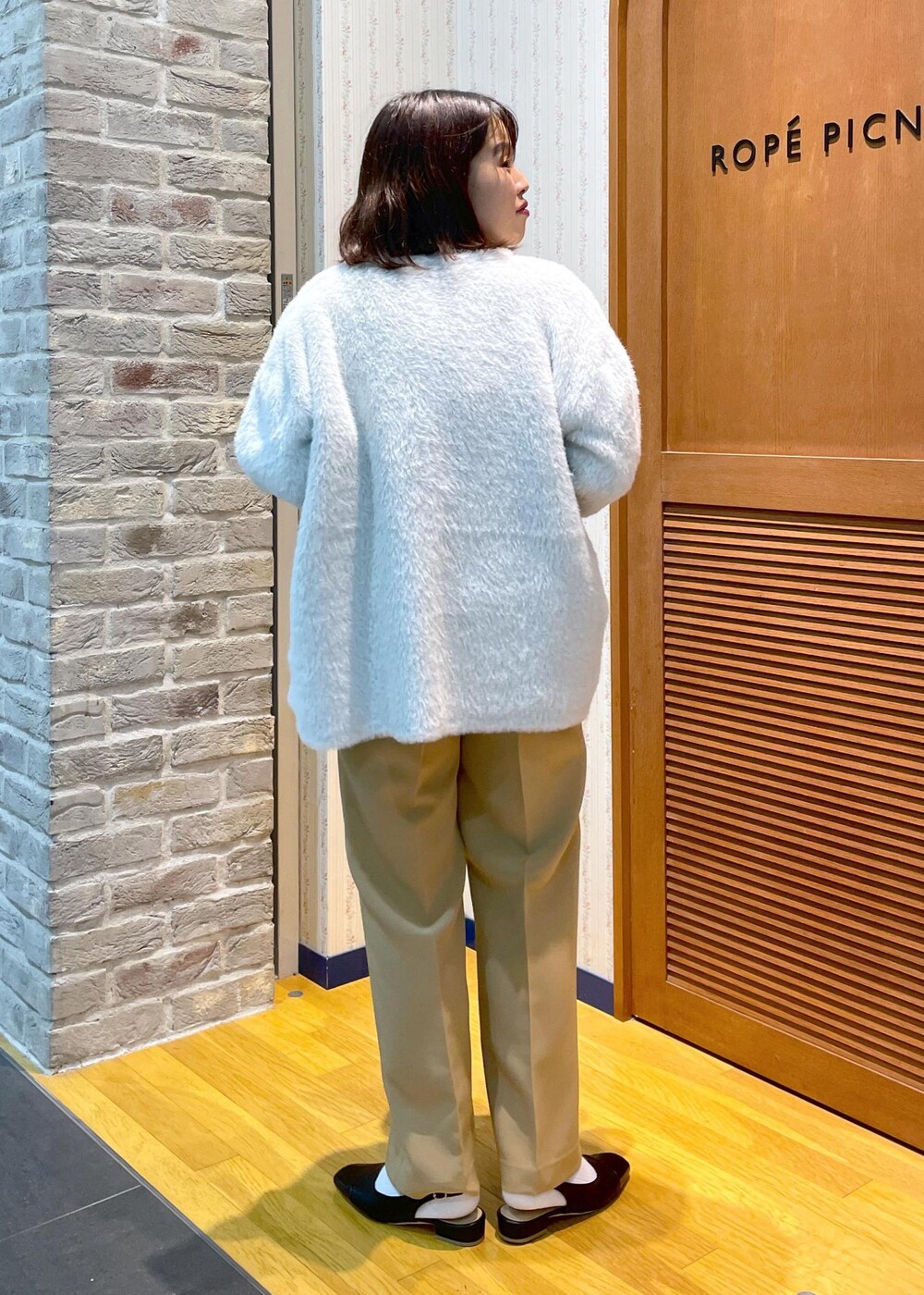 ホワイト系のその他アウター、ブラック系のニット/セーター、イエロー系のその他パンツを着用したレディースの秋コーディネートの3枚目の写真