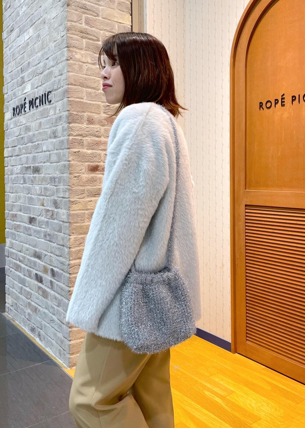 ホワイト系のその他アウター、ブラック系のニット/セーター、イエロー系のその他パンツを着用したレディースの秋コーディネートの5枚目の写真