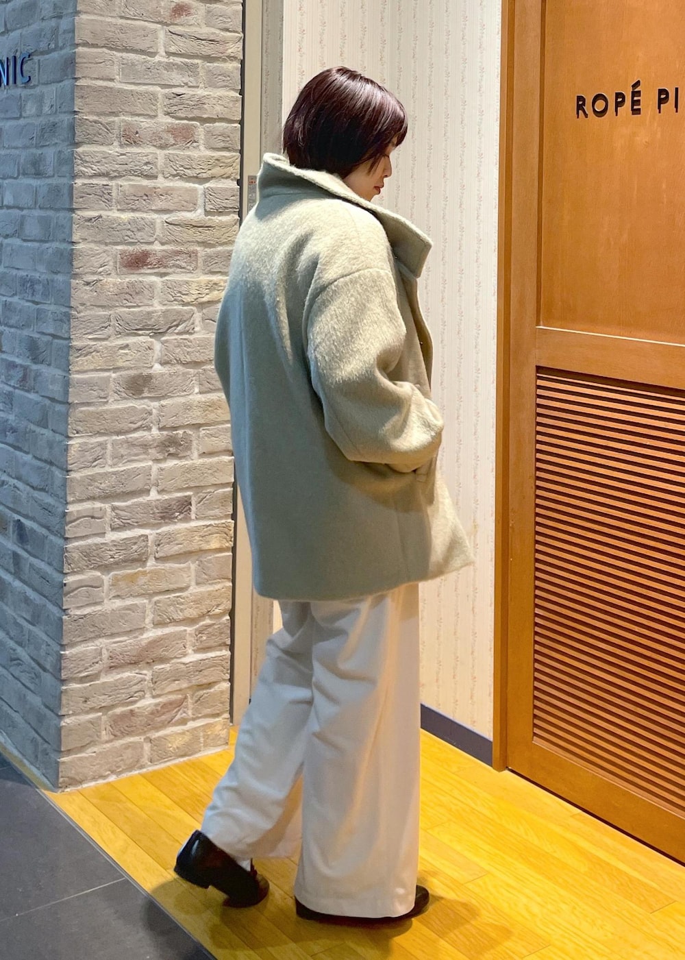 ホワイト系のニット/セーター、グリーン系のその他アウター、ブラック系のショルダーバッグを着用したレディースの冬コーディネートの4枚目の写真