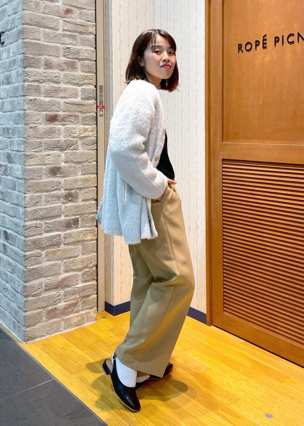 ホワイト系のその他アウター、ブラック系のニット/セーター、イエロー系のその他パンツを着用したレディースの秋コーディネートの7枚目の写真